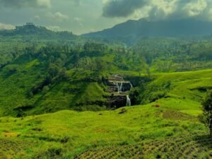 a lush green valley with a waterfall in the middle